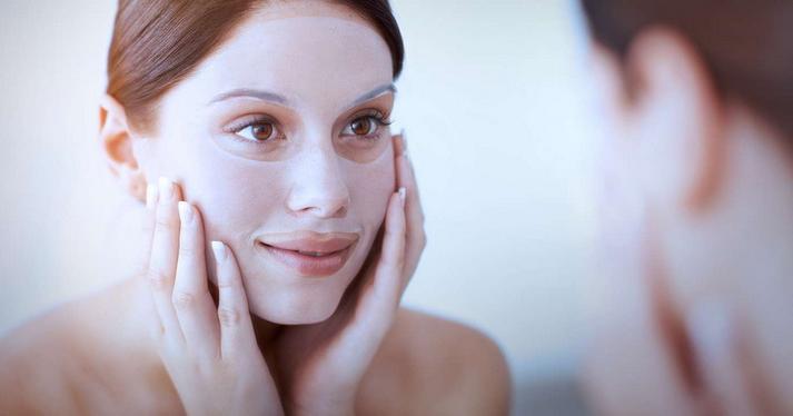 woman putting on a facial mask